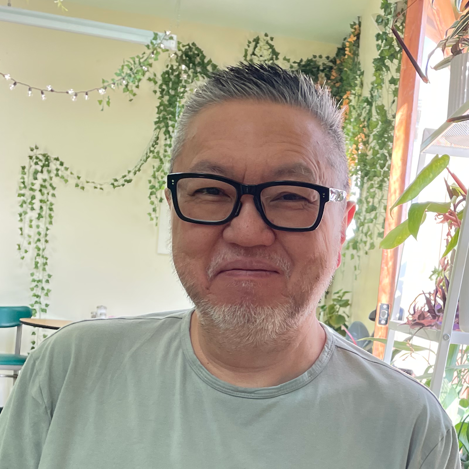 Head and torso picture of Bryan wearing a mint green t-shirt, glasses, and a very nice smile.